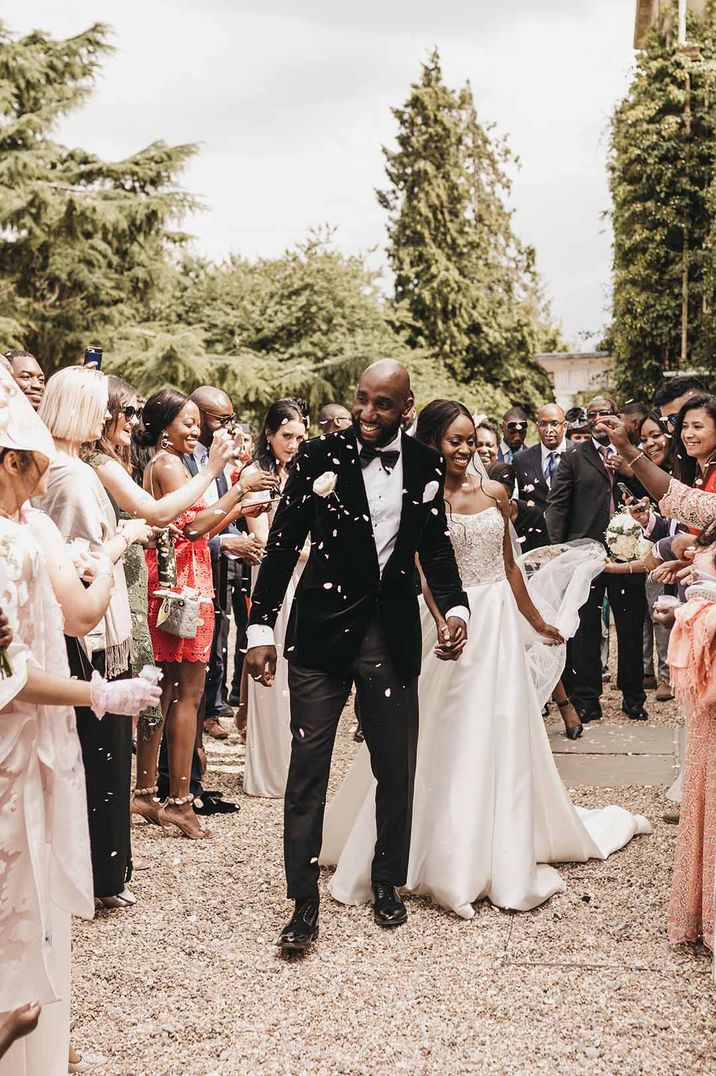 Bride in strapless wedding dress and groom in black suit at their traditional wedding