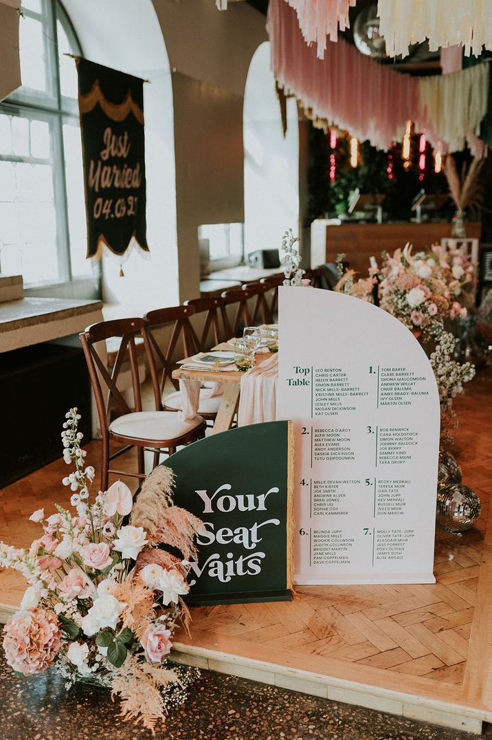 Green and white wedding table plan with curved design with pink and white wedding flowers with pampas grass, roses, and anthuriums 