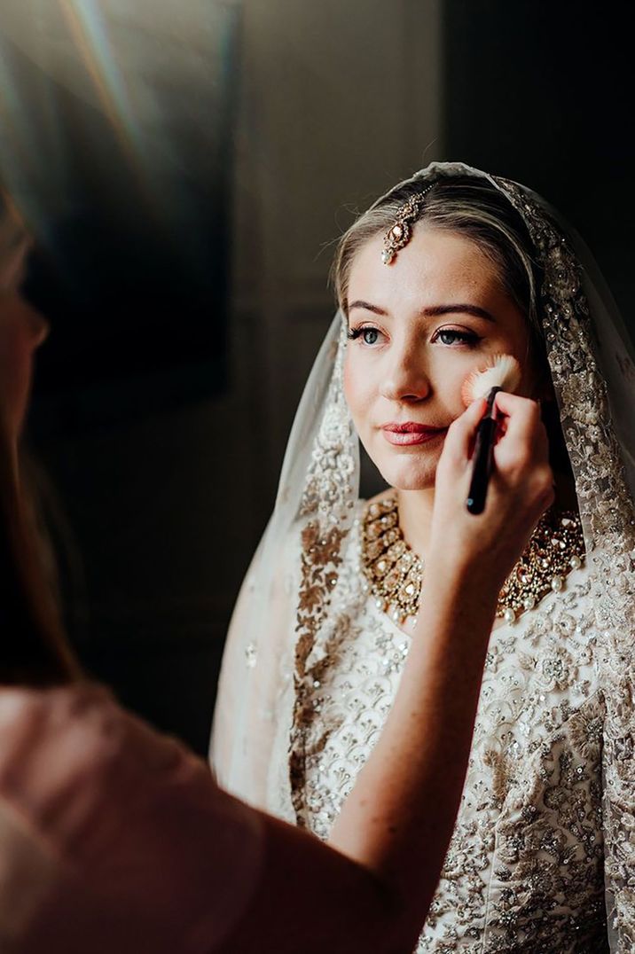 Bride gets her finishing touches to her makeup for the wedding day 