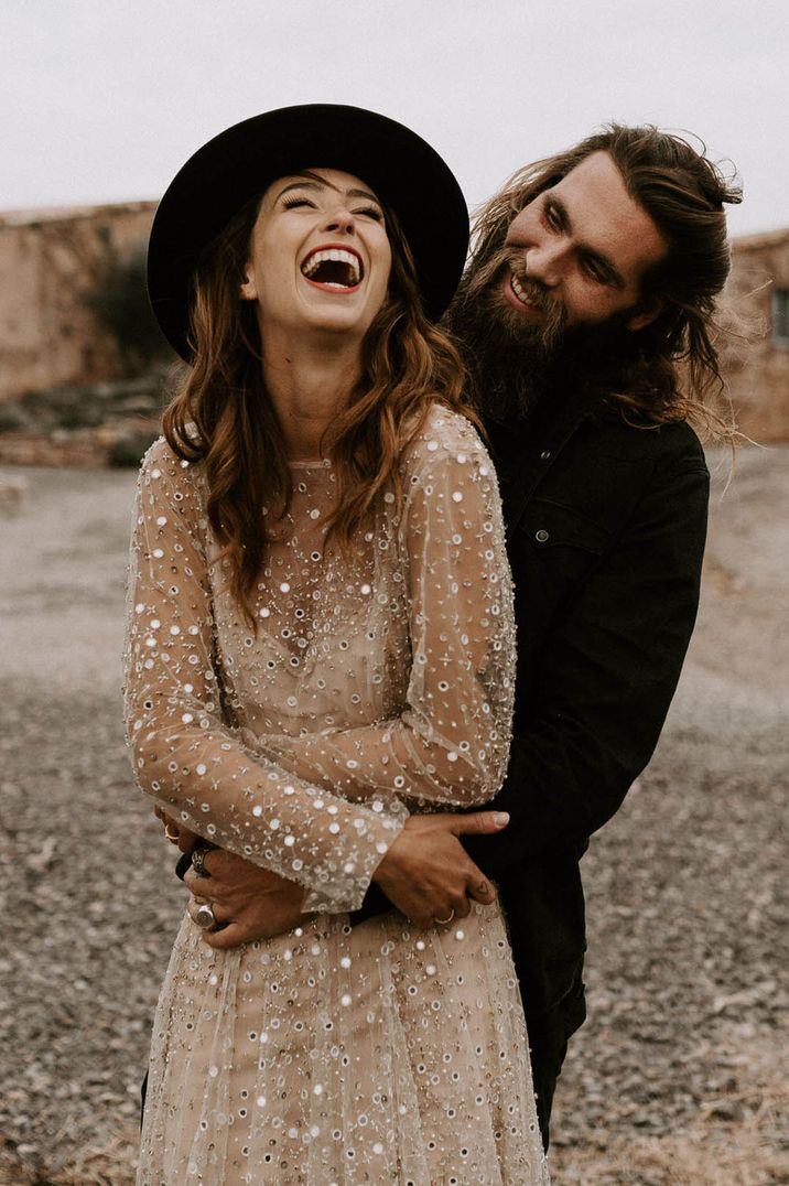 Bride wears nude sequin wedding dress complete with slip and black wide brim hat 