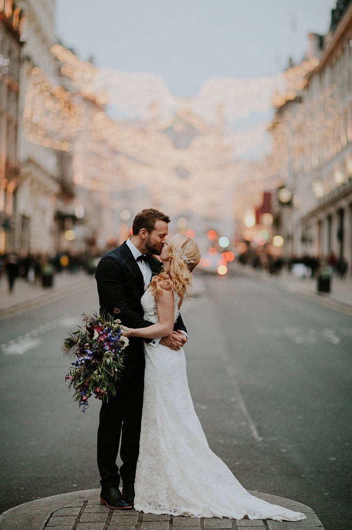 Bride and groom hug each other for their city wedding in London with lights