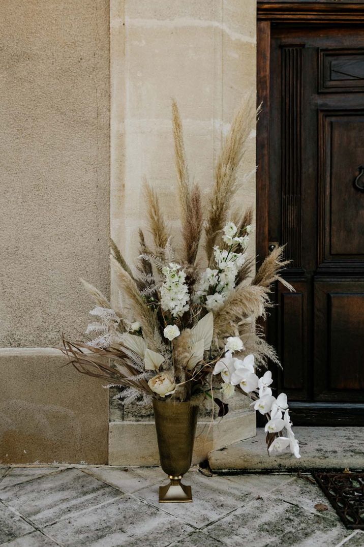 60k wedding with neutral wedding floral arrangements and pampas grass, palm leaves, and orchids 