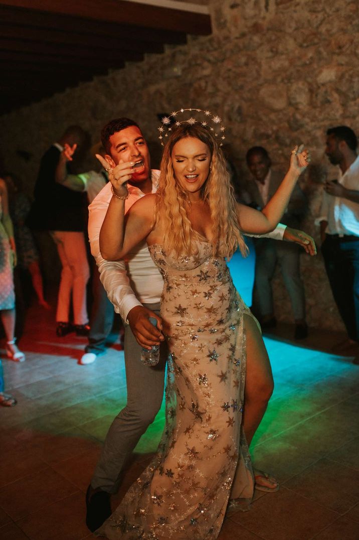 Bride in celestial wedding dress with celestial wedding headband dancing with husband at wedding party 