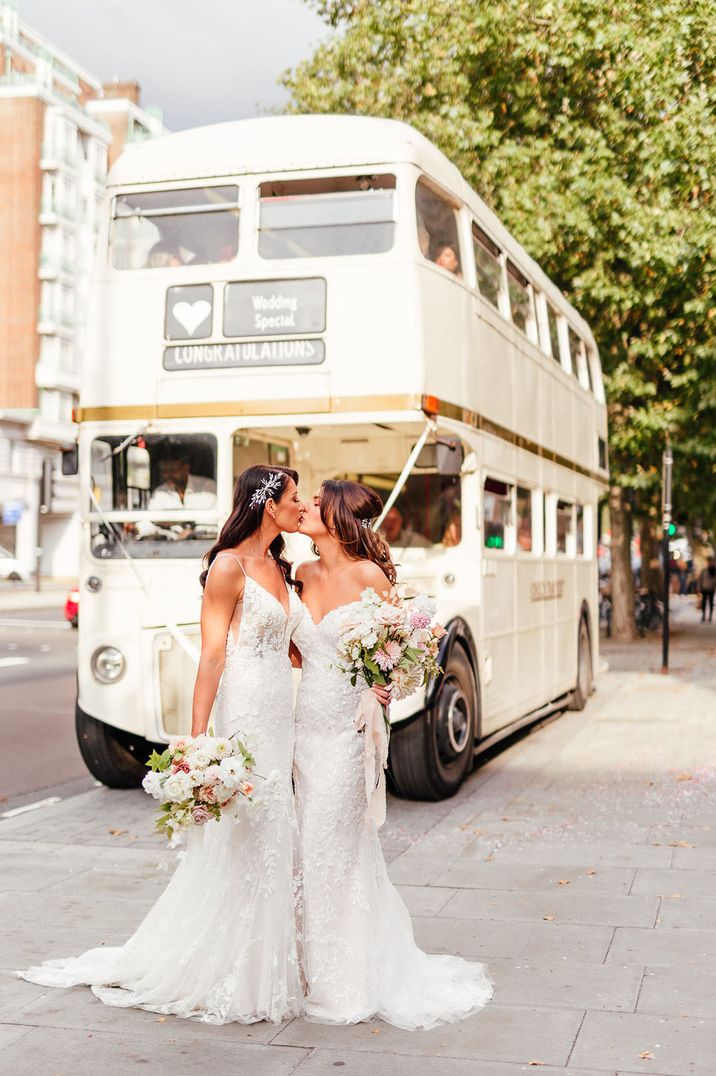 London Lesbian wedding with two brides kissing in front of a cream double decker bus