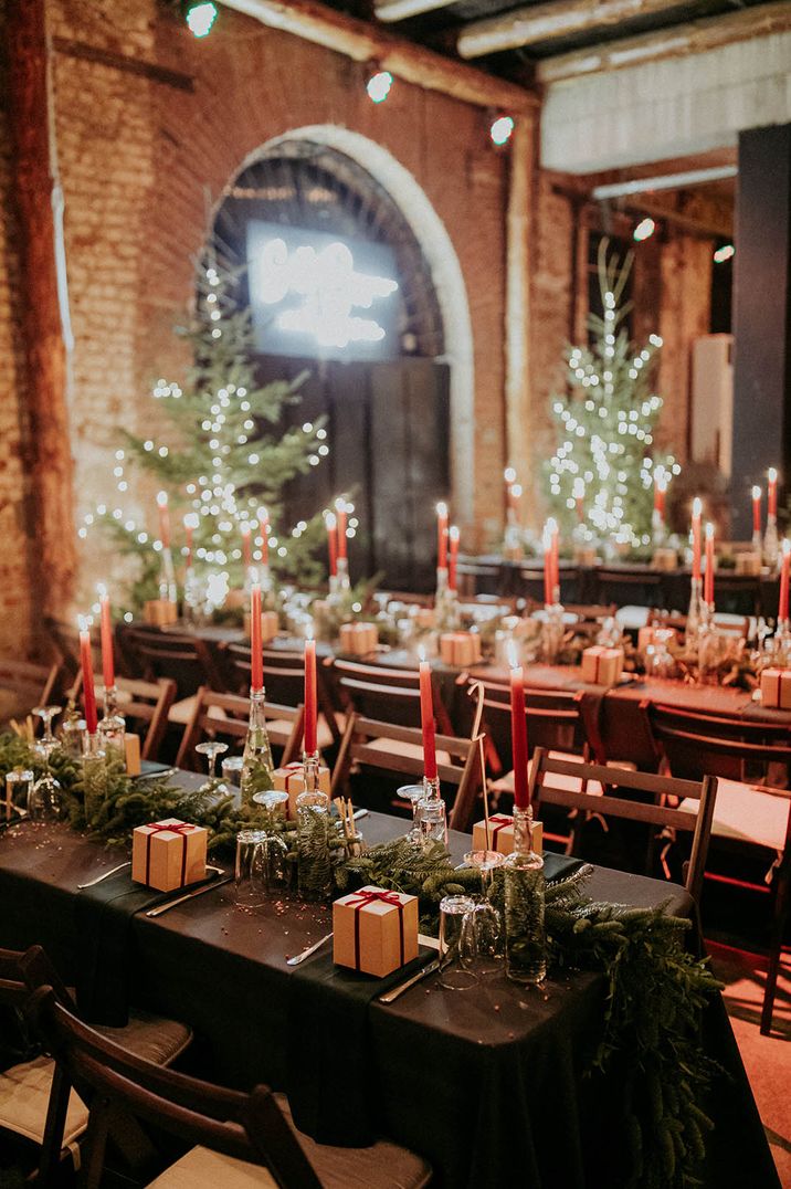 Warmly lit wedding reception tablescape with festive garland and gift favours for a winter wedding 