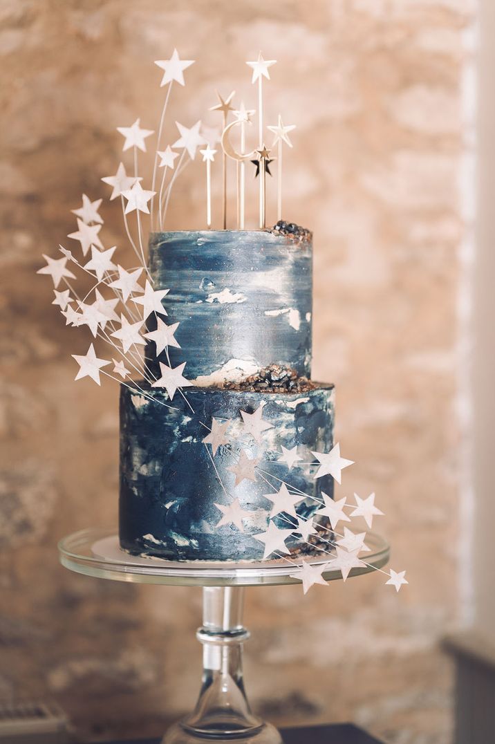 Night-sky inspired two tier wedding cake with midnight blue icing, crystals and moon and stars decorations 