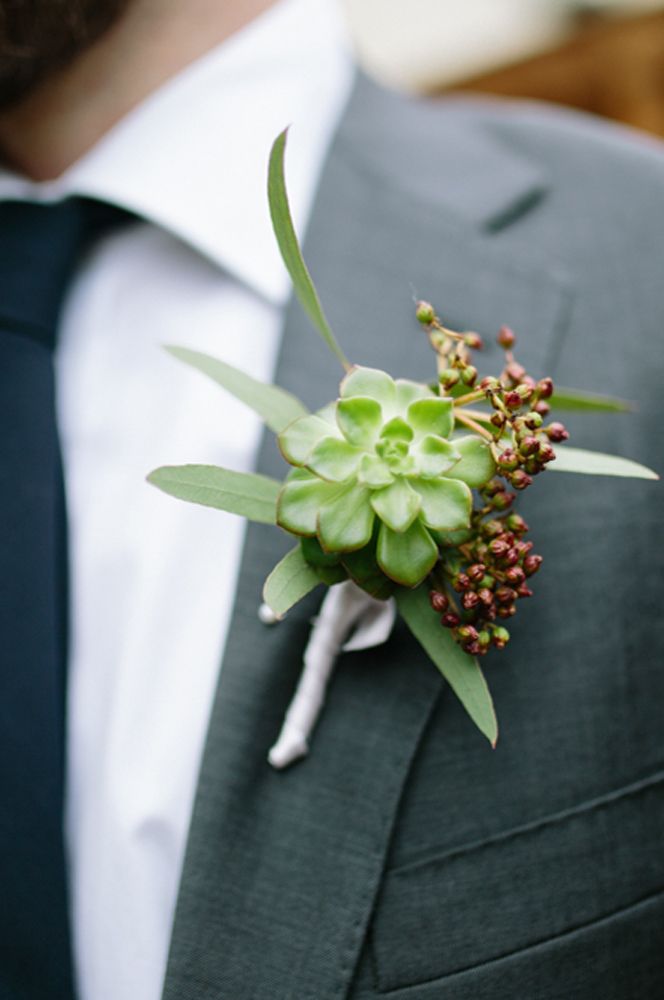 Groom in a grey suit with succulent groom buttonhole