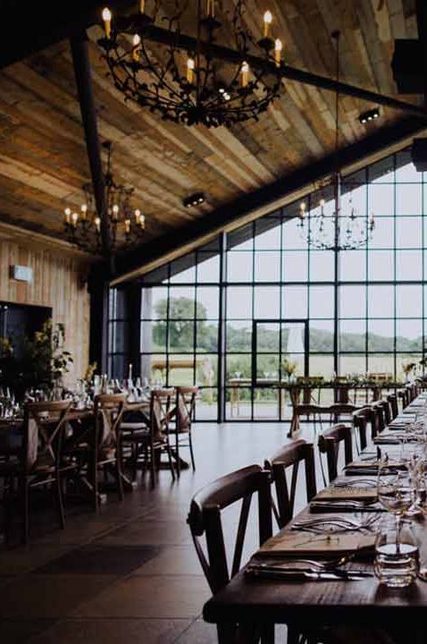 Modern wedding tablescape at The Barn at Botley Hill - black chandeliers, wooden tables, minimalistic wedding centrepieces and dried flower arrangements 