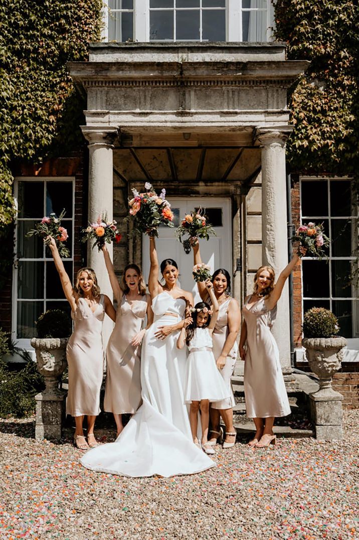 Outdoor wedding at Wootton Hall with the bridesmaids in gold satin midi bridesmaid dresses with the bride in Jesus Peiro outfit 