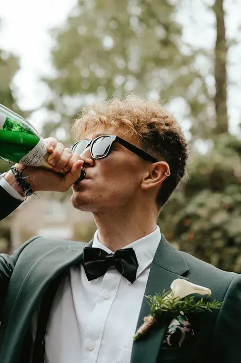 Groomsmen drinking sparkling wine from the bottle by Cara Zagni Photography