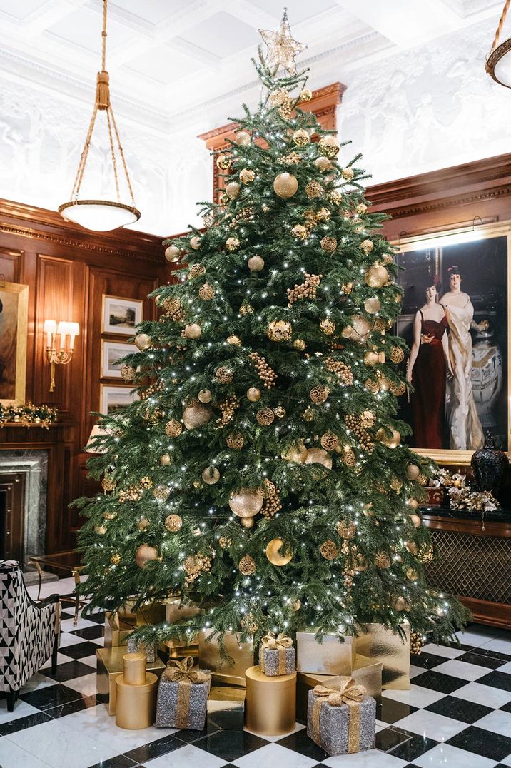 Large Christmas tree with golden decorations at wedding