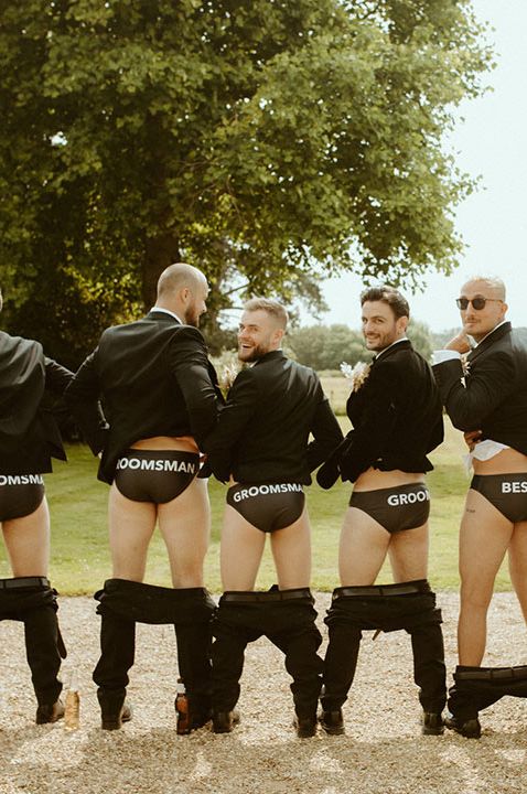 Groomsmen in tuxes showing personalised underwear 