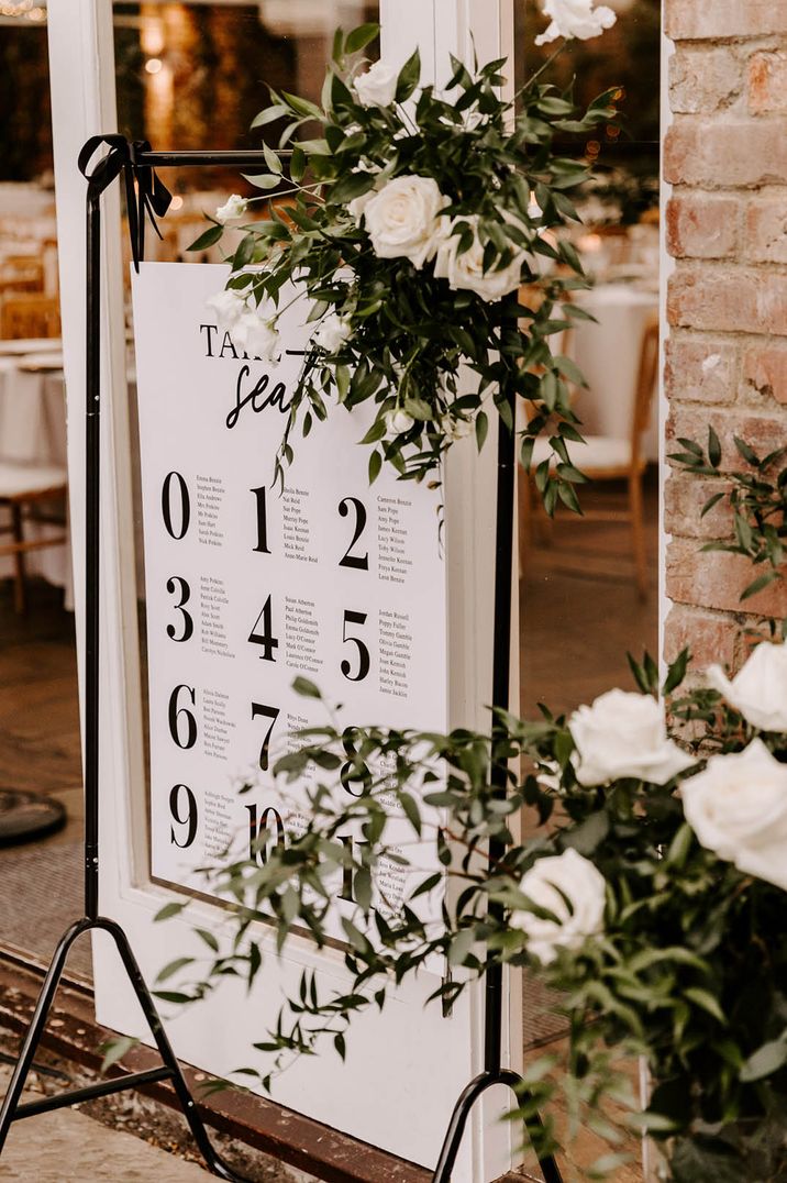 Large number black and white seating chart with decorative foliage 