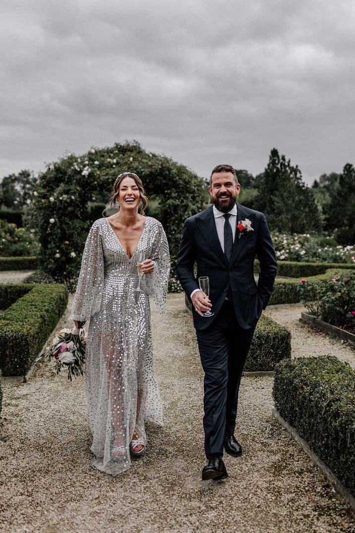 Bride in a silver sequin wedding dress and groom in a navy suit at fun wedding 