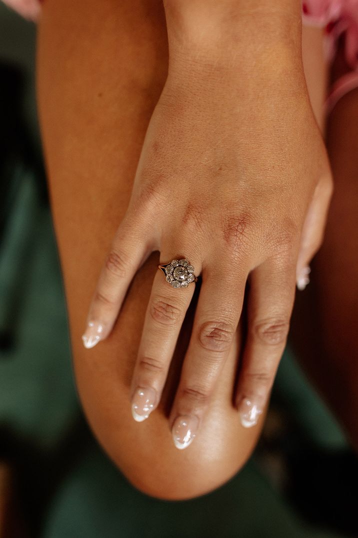 Flower vintage diamond engagement ring worn by bride with pearl nails 