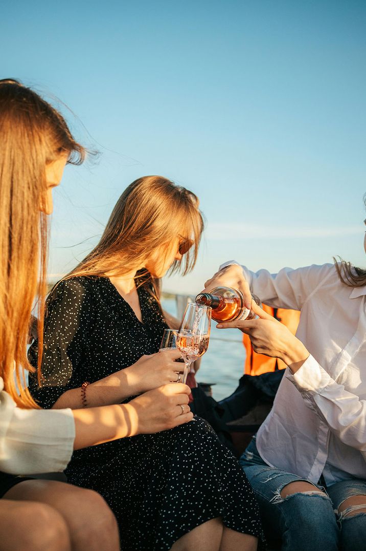 Stock image of man pouring a drink for a woman on a boat 