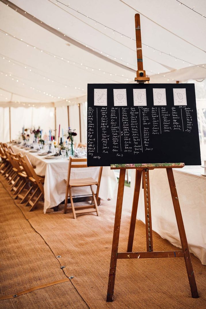 DIY chalkboard seating plan on an easel at marquee wedding