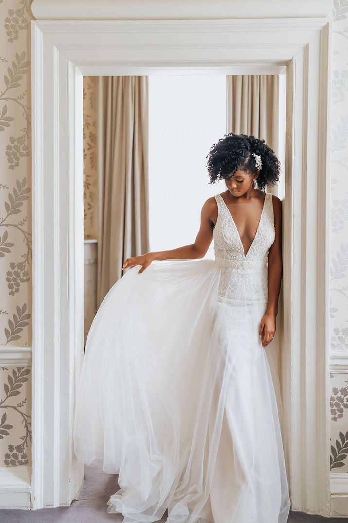 Black bride in a plunging neckline wedding dress with full skirt