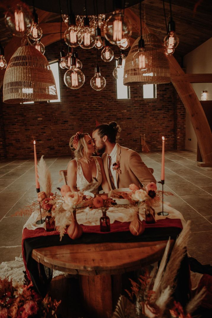 Sweetheart table at intimate wedding with the bride and groom sitting side by side 