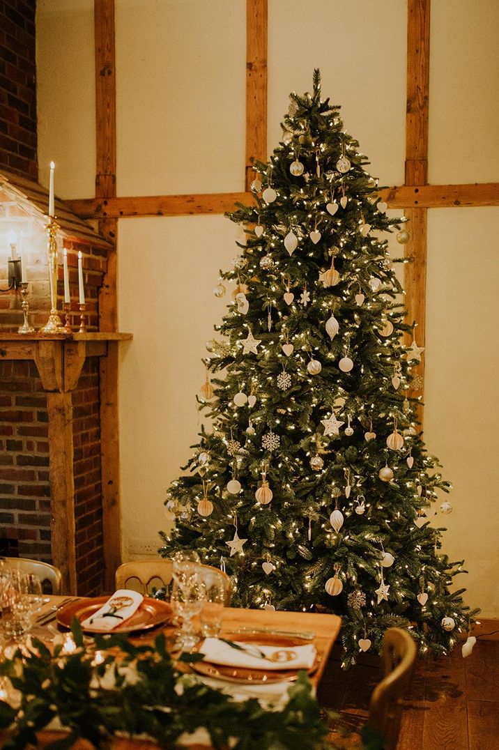 Winter wedding decorations with white and gold baubles on the Christmas tree