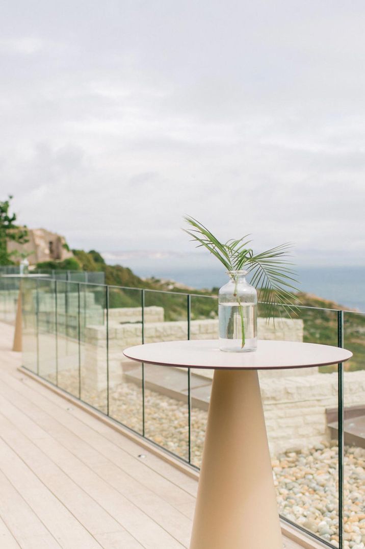 Balcony at Pennsylvania Castle Estate wedding venue with clear vase and single plant decor looking out onto the sea 