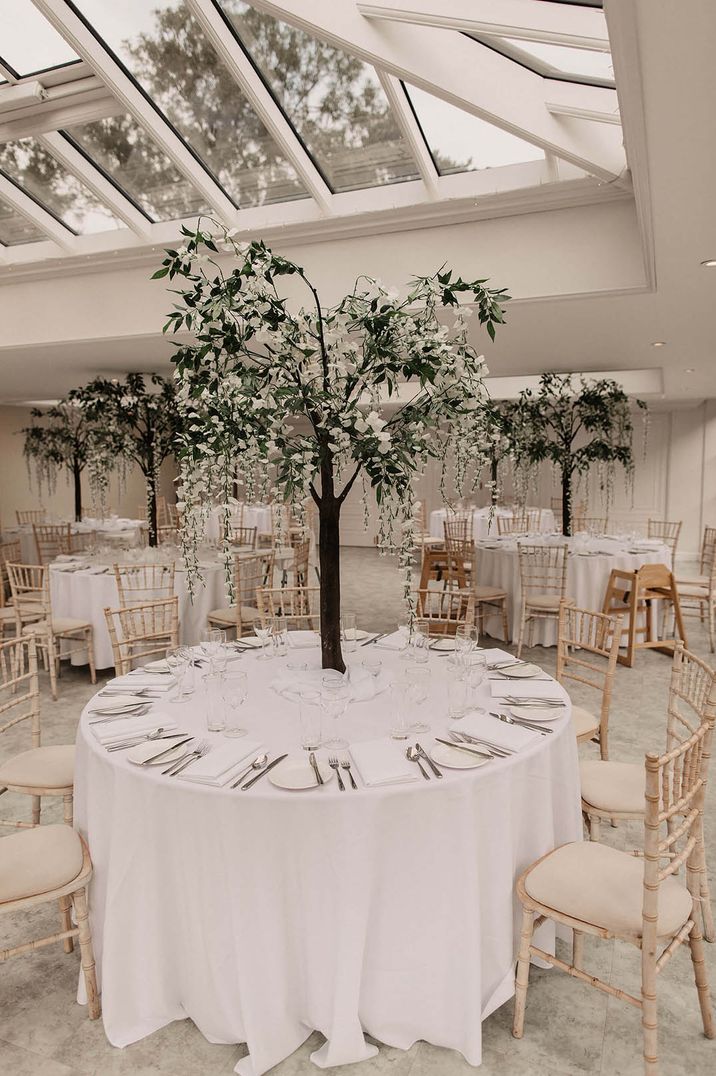 Circular all white wedding tablescape with a tree centrepiece for luxe country house wedding under 40k 