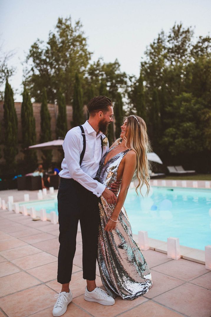 Bride in a shimmering silver metallic long gown for the reception with the groom for their wedding in France 