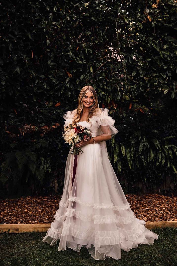 Bride in sheer sleeve layered tulle Halfpenny London mayfair wedding dress with sheer overlay 