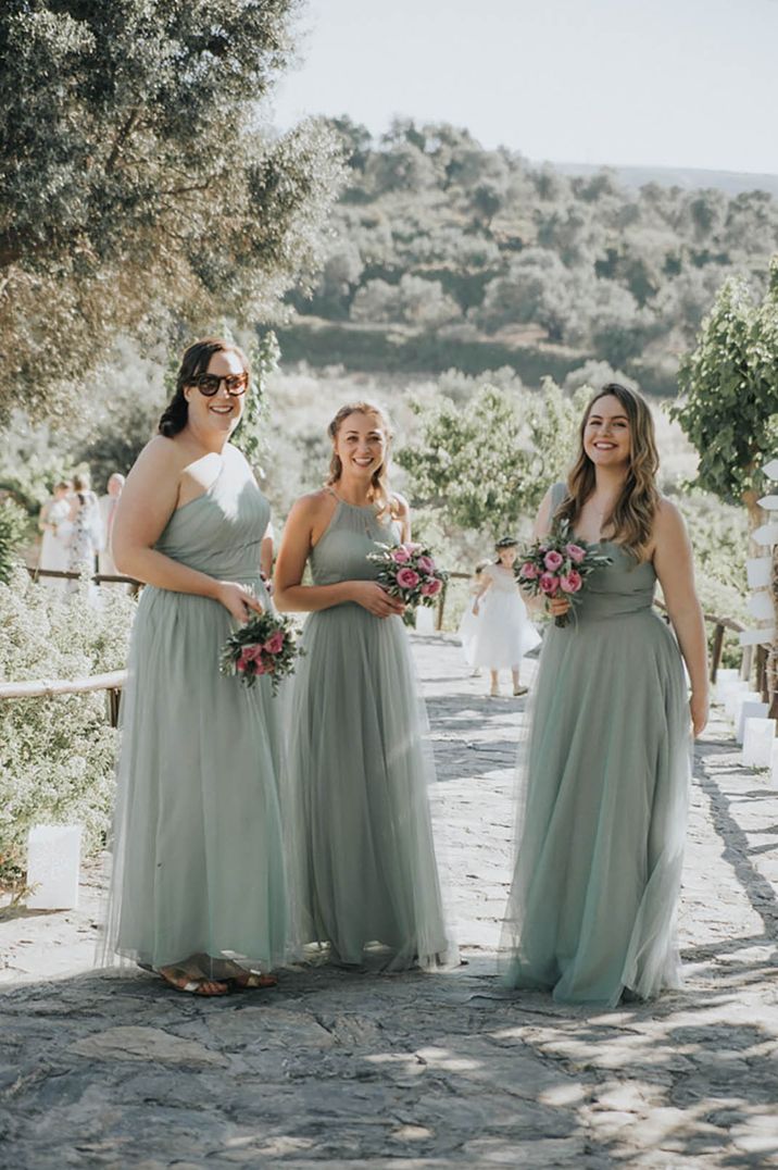 Bridesmaids in different style mint green bridesmaid dresses with pink rose bouquets 