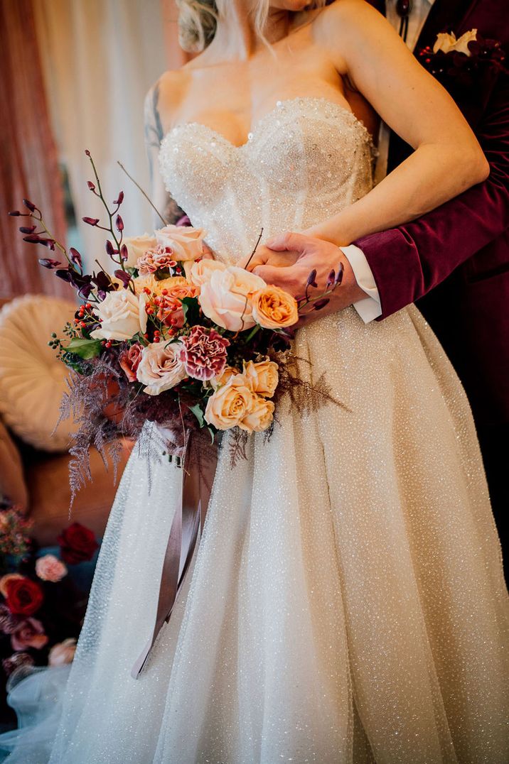 Red and white carnations in winter wedding bouquet with roses and winter berries 