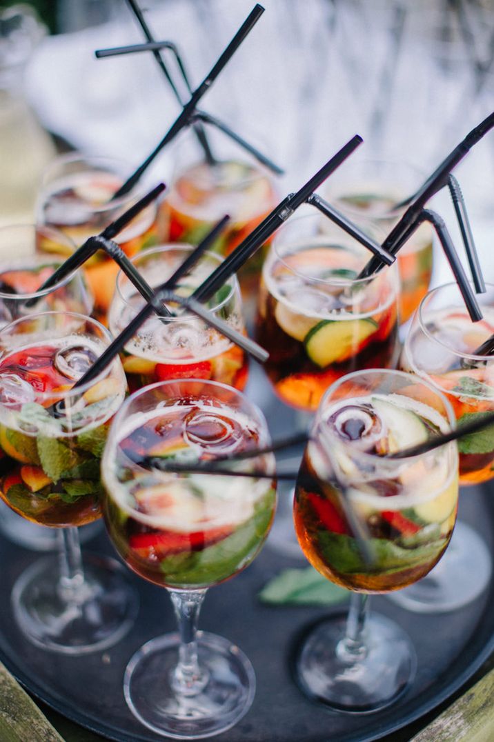 Wine glasses filled with Pimm's cocktail with black straw