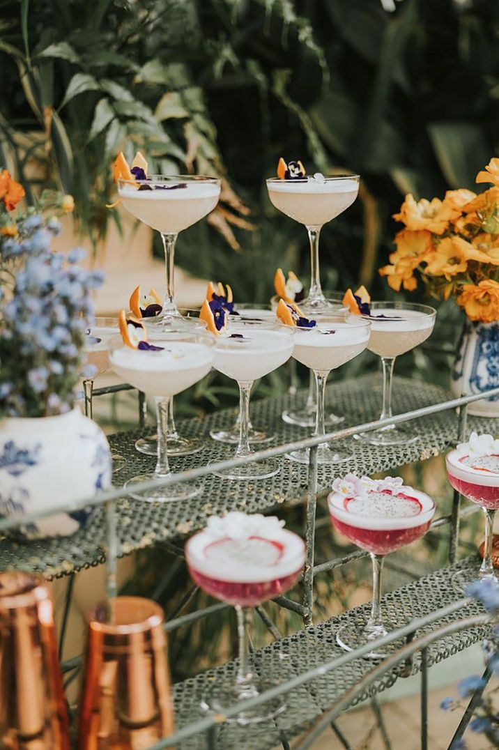 Cocktail tower decorated with orange peels and edible flowers for decoration 