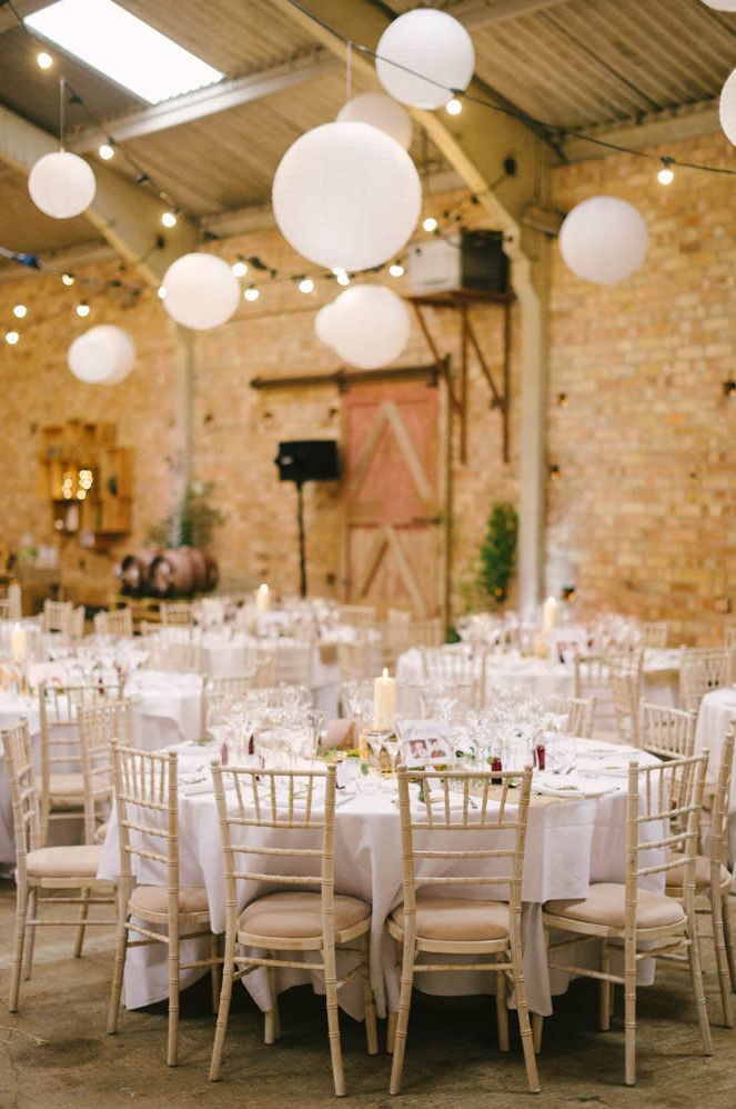 Rustic barn wedding reception with hanging lanterns and fairy light decor 