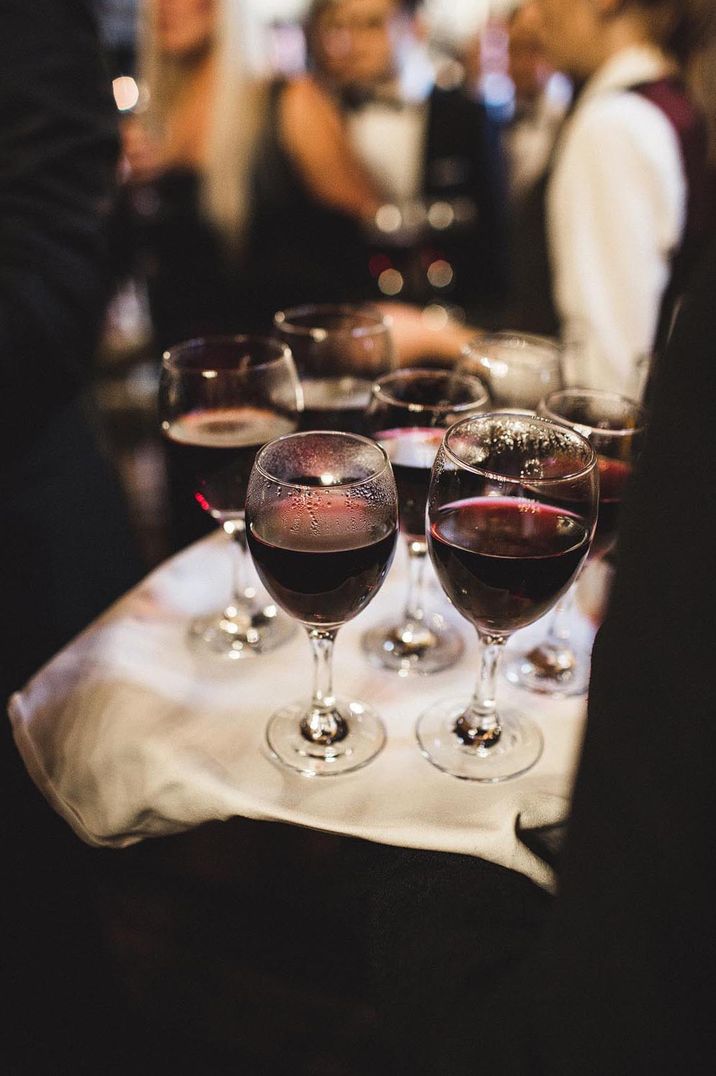 A tray of wine is given out at a winter wedding 