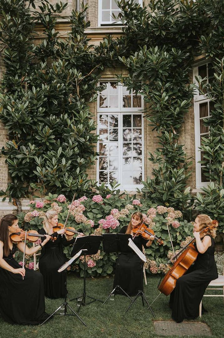 Outdoor wedding entertainment - zaffa band playing string instruments at Hedsor House 