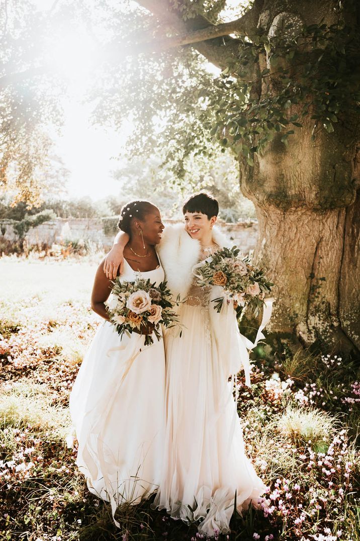 Bride in square neck wedding dress with pearl hair accessories with bride in lace dress with faux fur shawl 