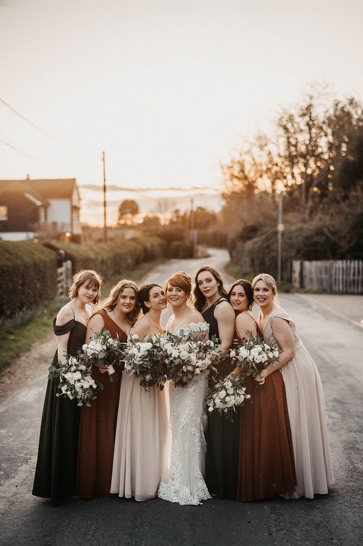 Rustic barn wedding with bridesmaid dresses in brown bridesmaid dresses with matching white flower bouquets 