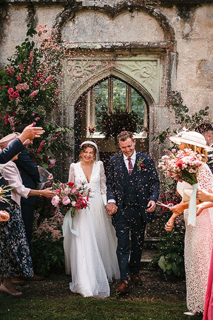 The bride and groom exit from their wedding ceremony to confetti 