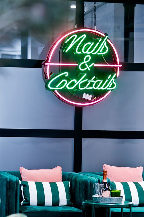 The salon interior at Beauty Club London including nail area with neon sign reading nails & cocktails