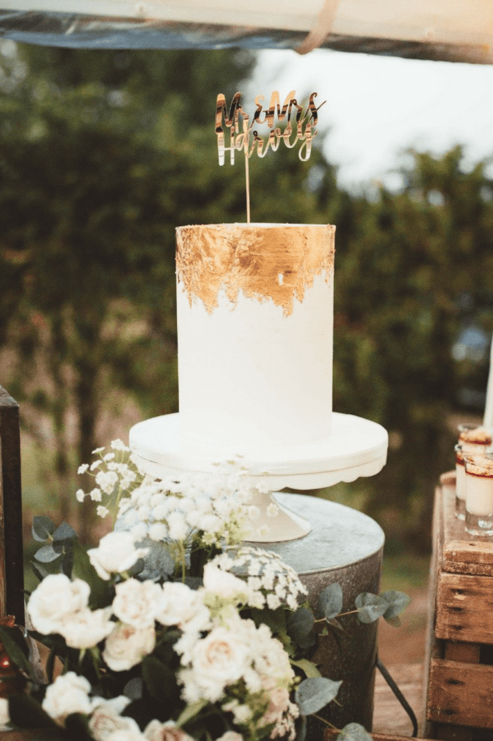 Single tier simple wedding cake with gold leaf detailing to the top