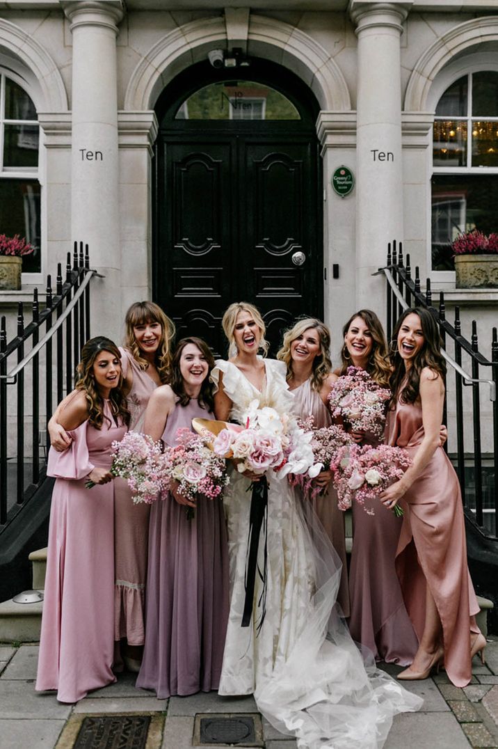 Weddings under 40k roundup with the bridal party with pink mismatched bridesmaid dresses and bride in ruffle dress 