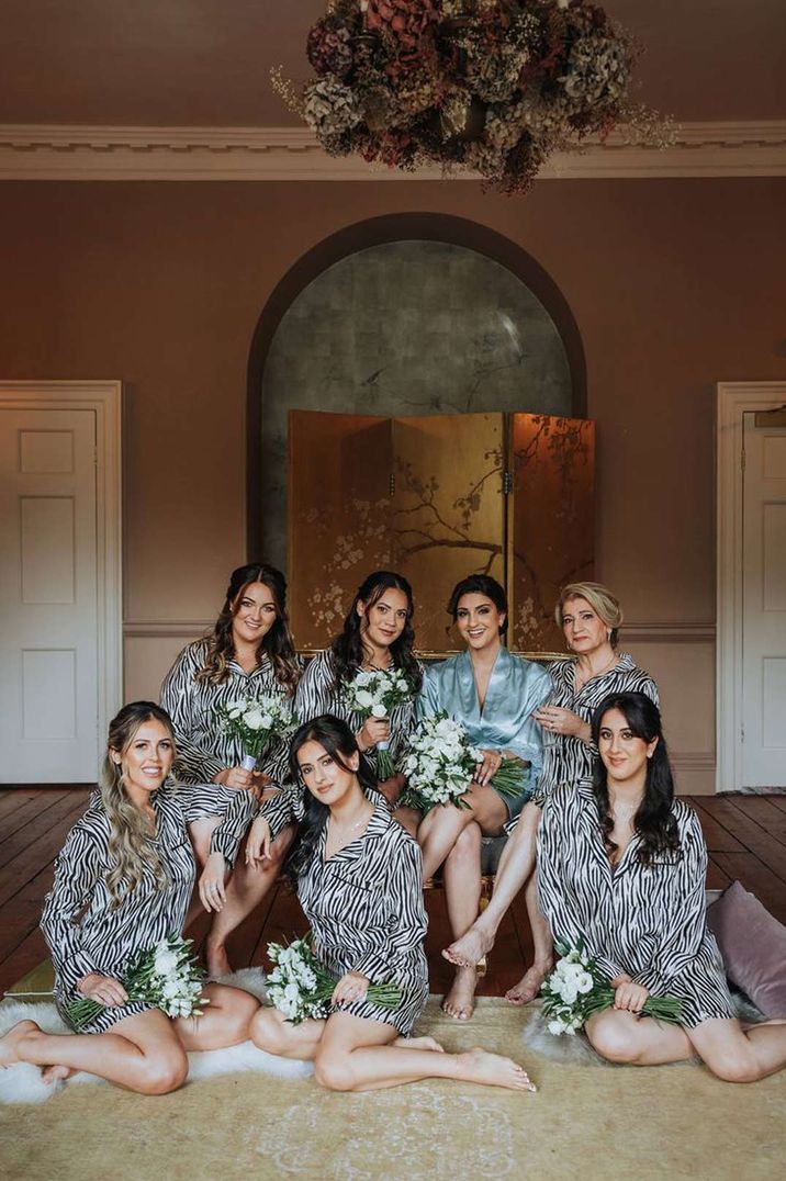 Bridesmaids in silk long sleeve zebra print pyjamas with bride in baby blue silk getting ready pyjamas at The Orangery Kent - timeline of wedding day 