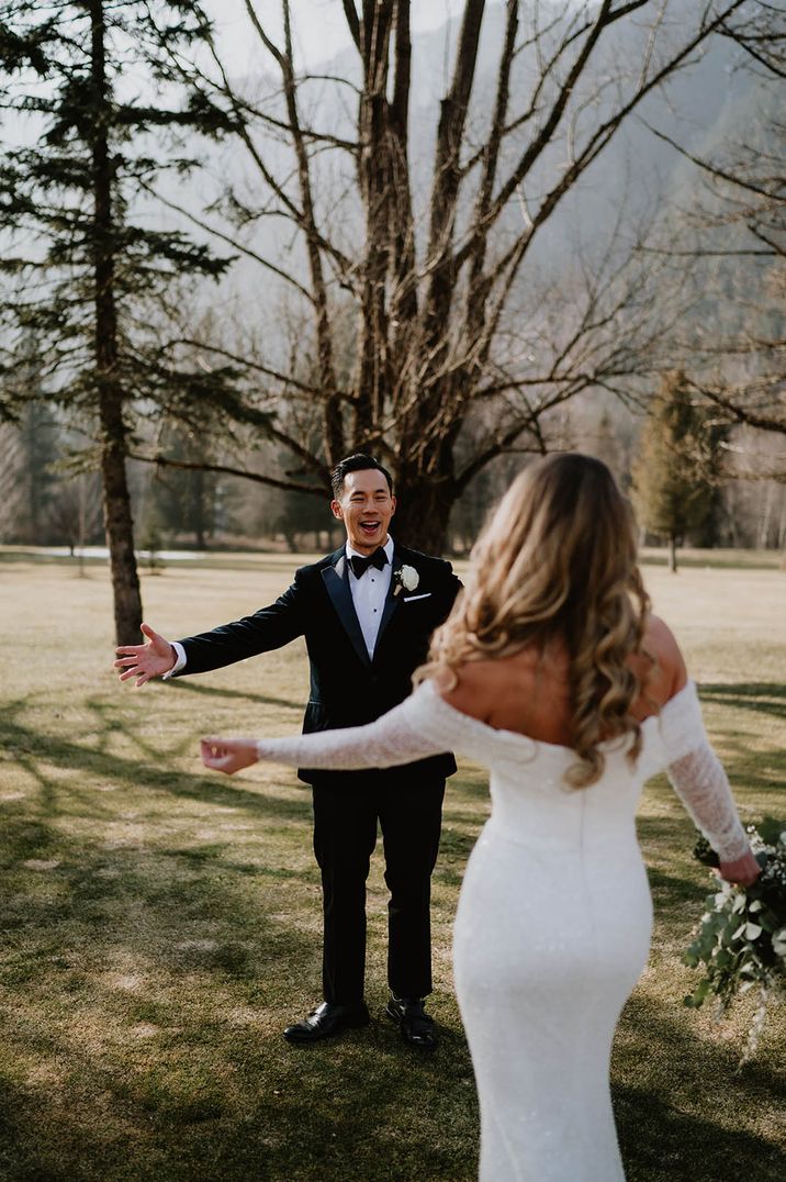 The bride and groom greet each other during their first look moment for ski wedding 