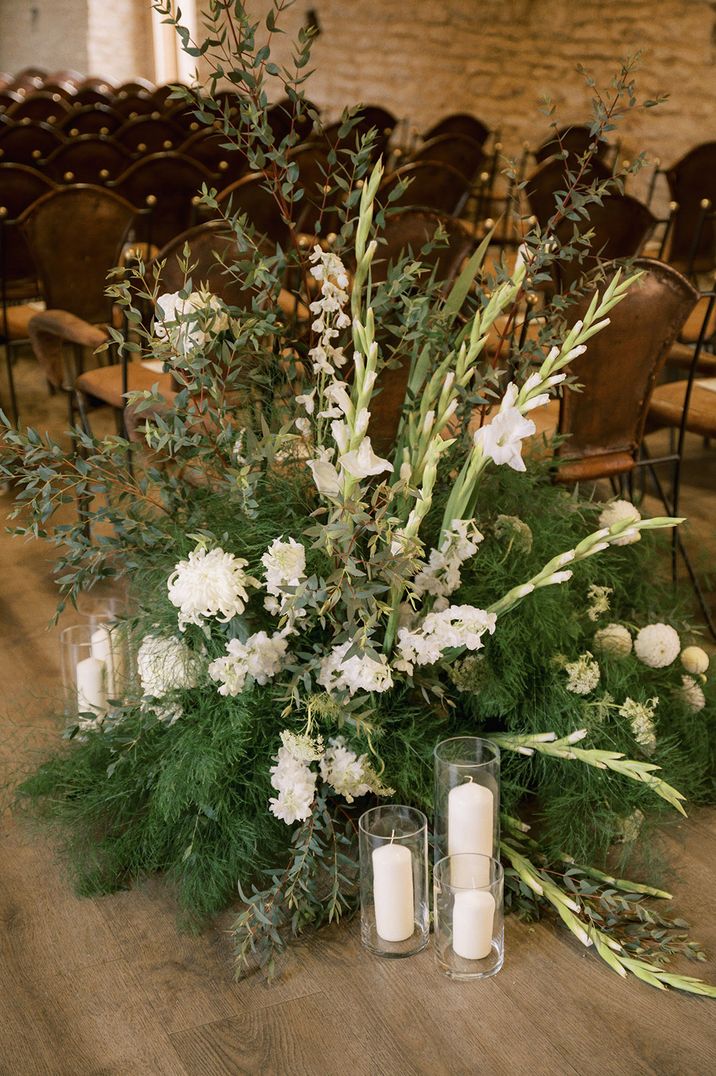 Stunning all white wedding aisle flower arrangements with greenery including gladiolus 