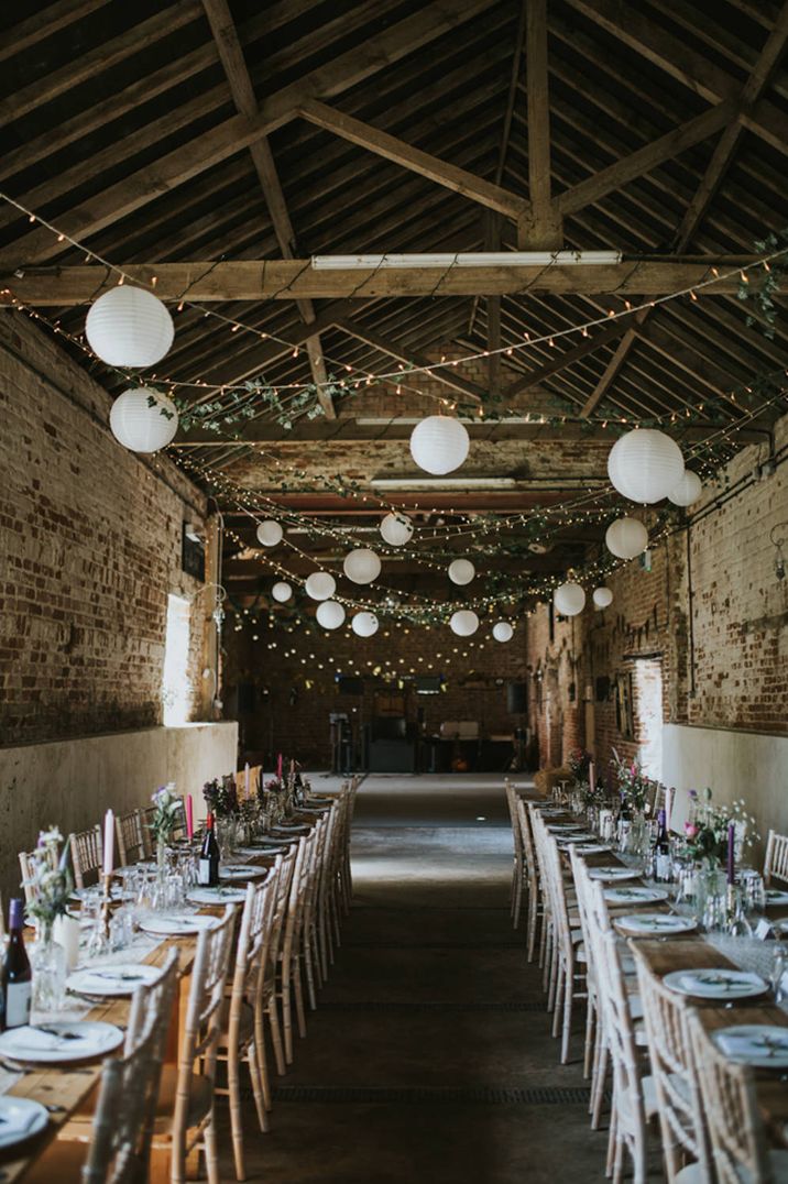 Rustic barn wedding reception with hanging lanterns and fairy lights 