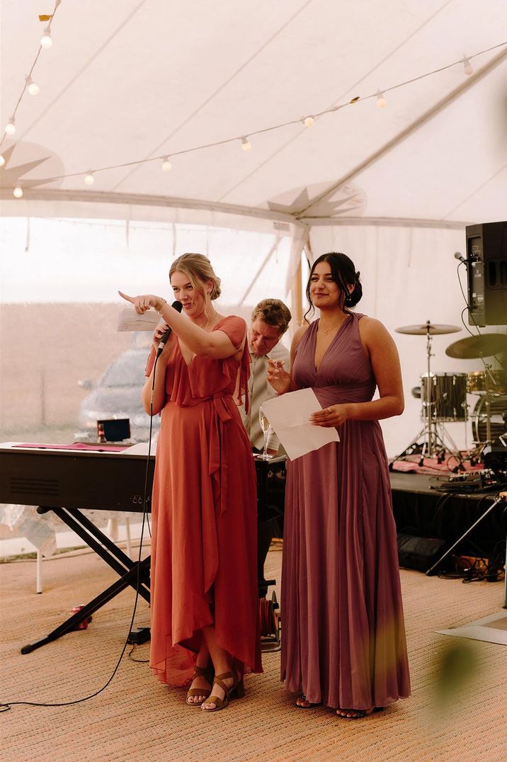 Maid of honour in burnt orange dress and bridesmaid in deep nude pink dress