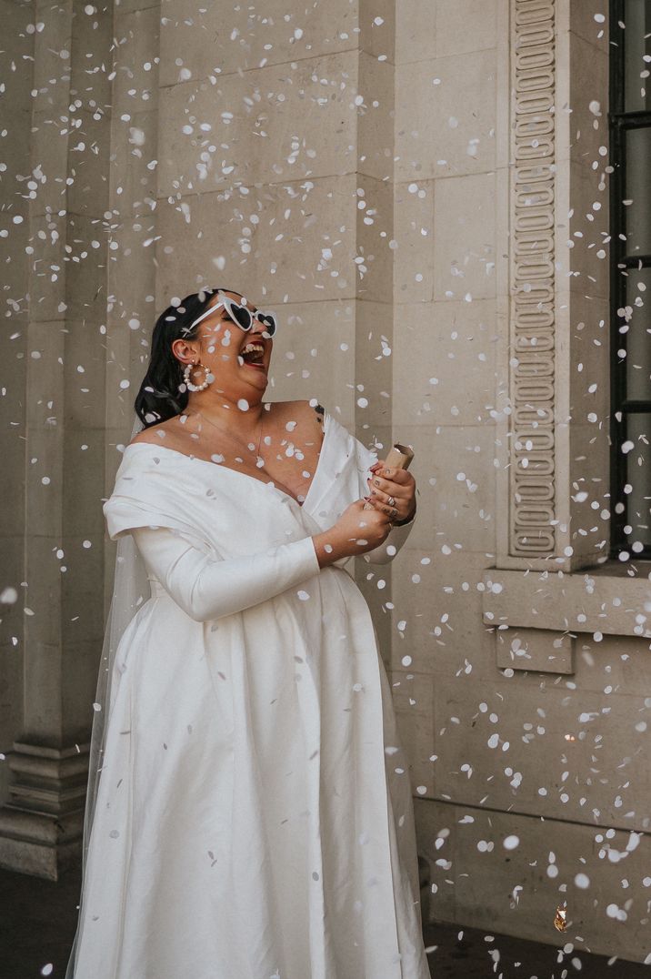 Bride wears long sleeve ASOS wedding dress and heart shaped sunglasses 