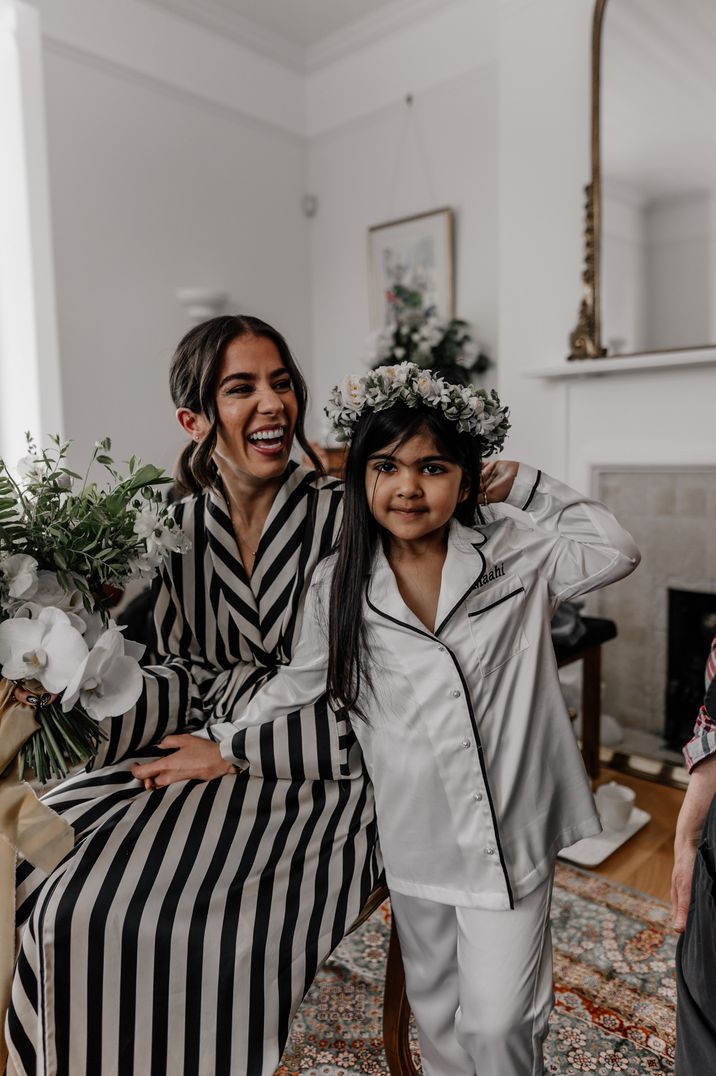 Bride in striped getting ready robe before wedding standing with child in white pyjamas 