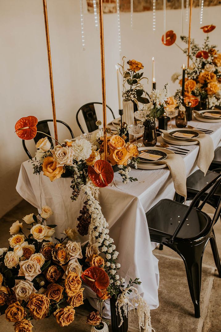 Anthuriums, roses, dahlias in orange and yellow shades for fall wedding table decorations 