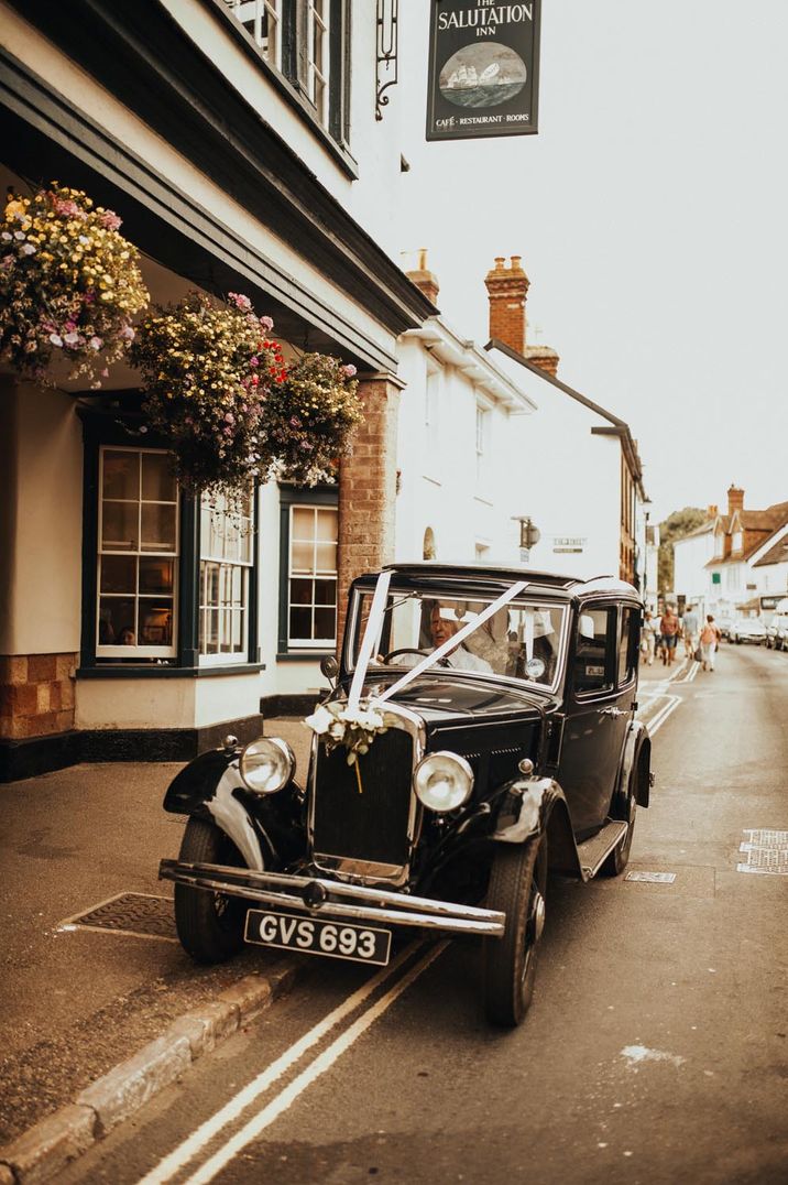 Black vintage wedding car with white lace decoration 